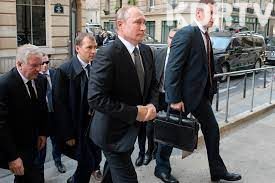 Putin with his security details carrying a suitcase
